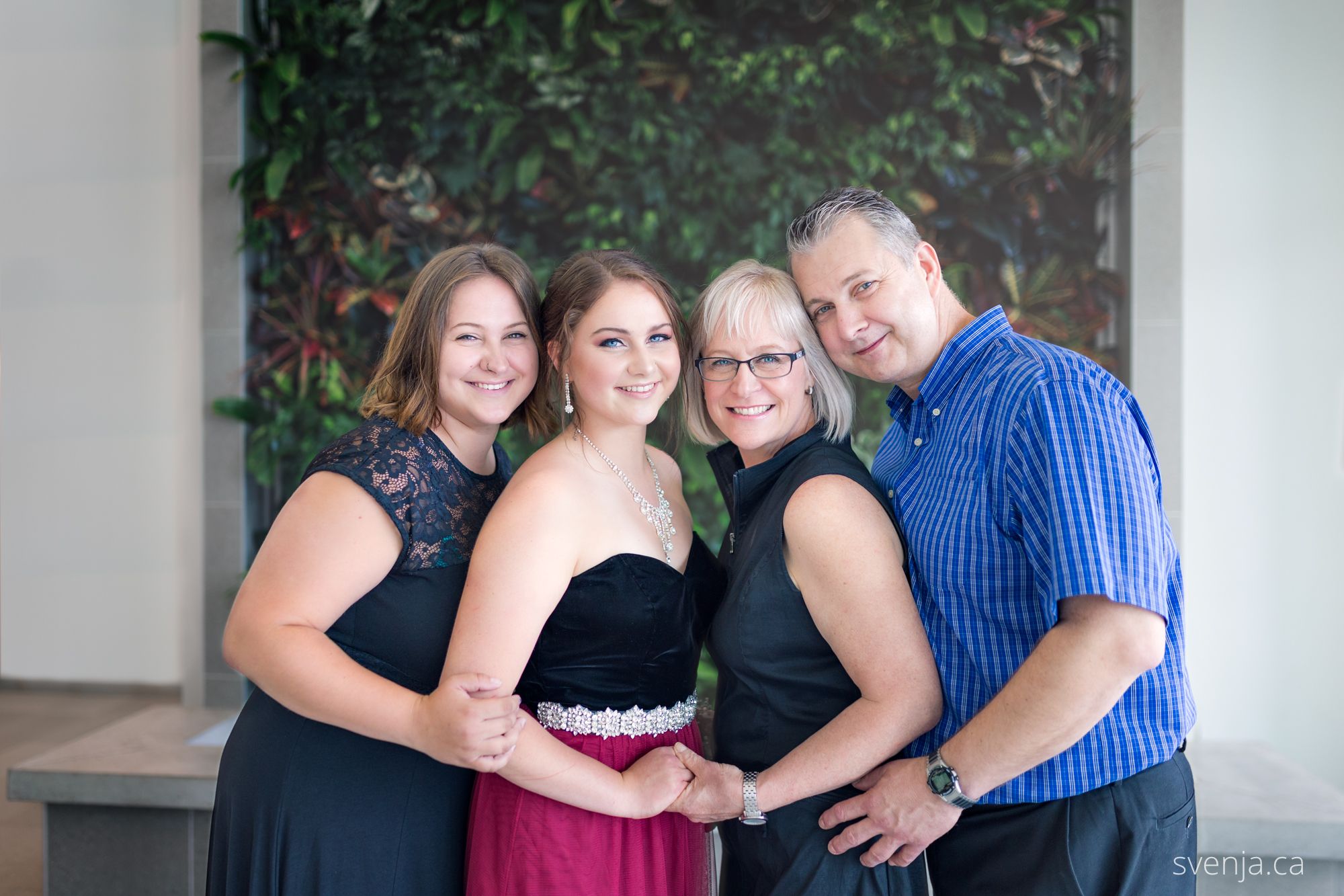 family of four takes a photo indoors