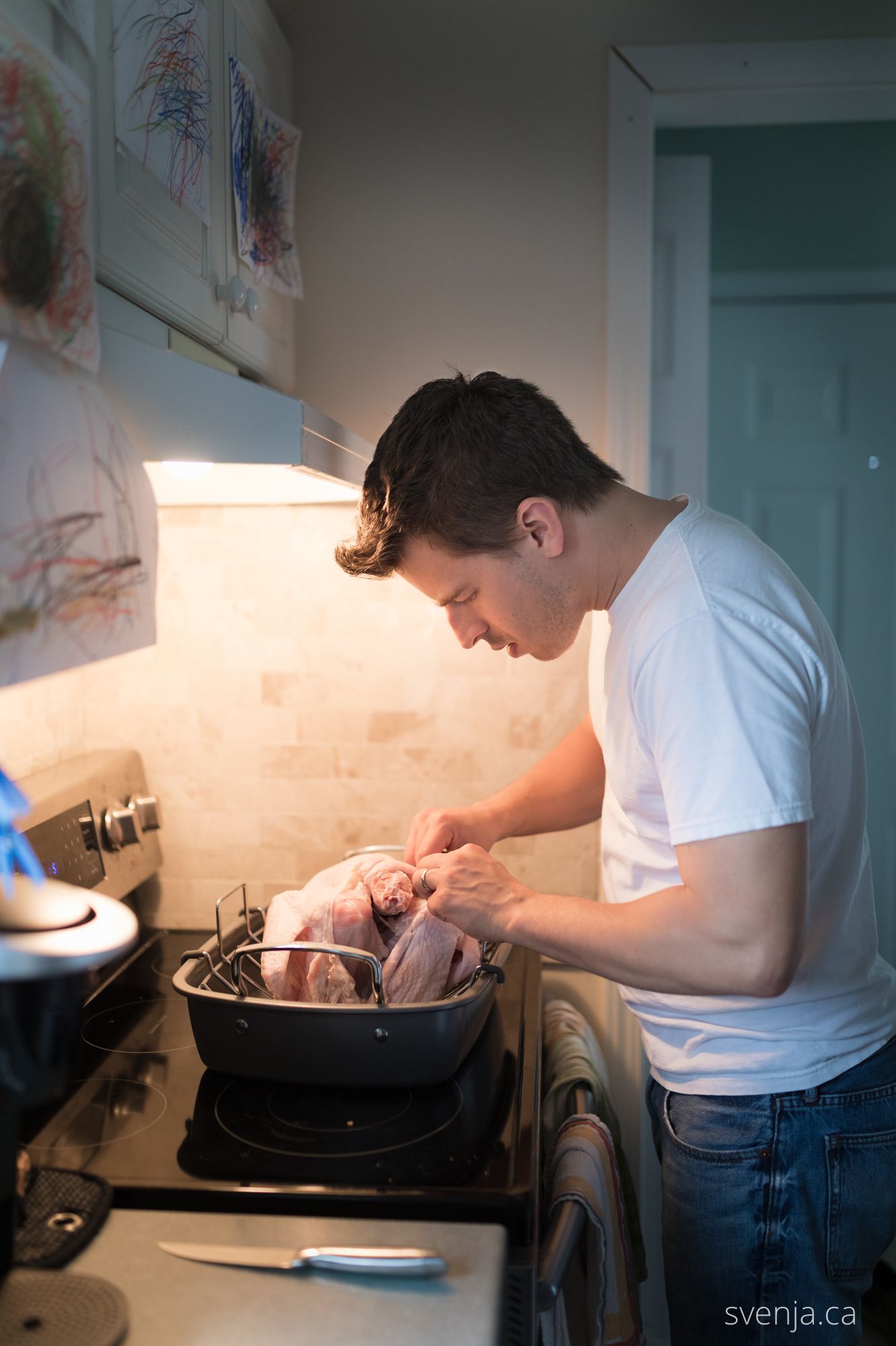 young man stuffing turkey for thanksgiving